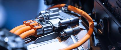 Close-up of orange high-voltage EV cables and connector behind Voldt EV charging cable technology
