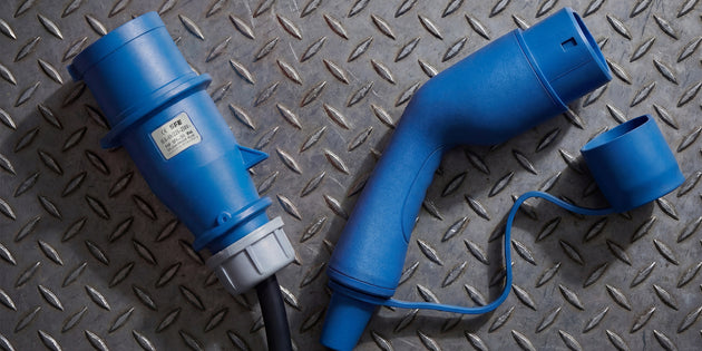Blue CEE industrial plug and Type 2 connector on a diamond plate steel surface