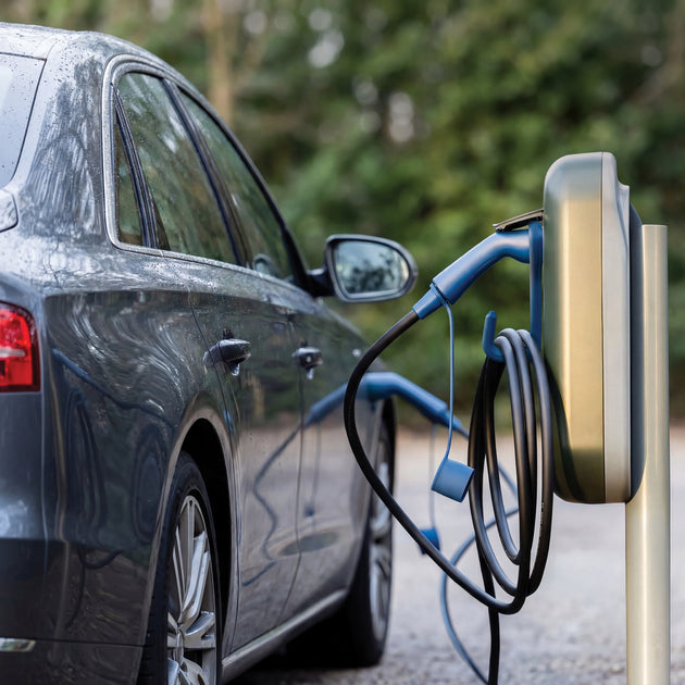 Dark blue Audi charging at a public charging post with a blue Voldt EV charging cable on a hook