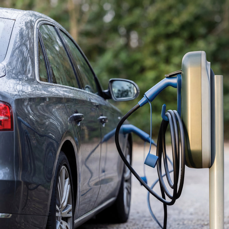 Dark blue Audi charging at a public charging post with a blue Voldt EV charging cable on a hook