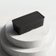 Closed black Voldt® EV cable storage box displayed on a stone plinth