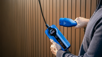 Hands holding a blue Voldt portable Type 2 EV charging cable with control box